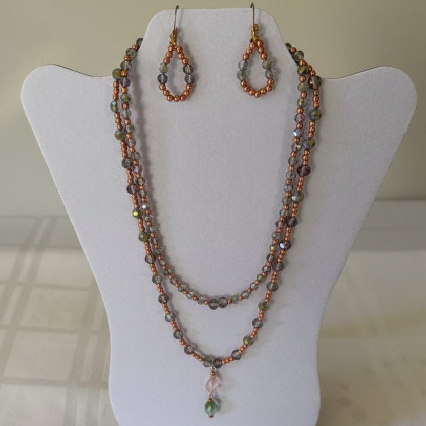 Beaded necklace and earrings on a white mannequin bust.