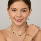 Young woman wearing a colorful necklace, earrings, and bracelet against a plain background